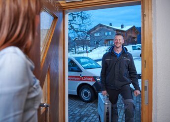 Kundin macht von innen die Haustür für einen Techniker vom bösch Kundendienst auf | © bösch heizung.klima.lüftung